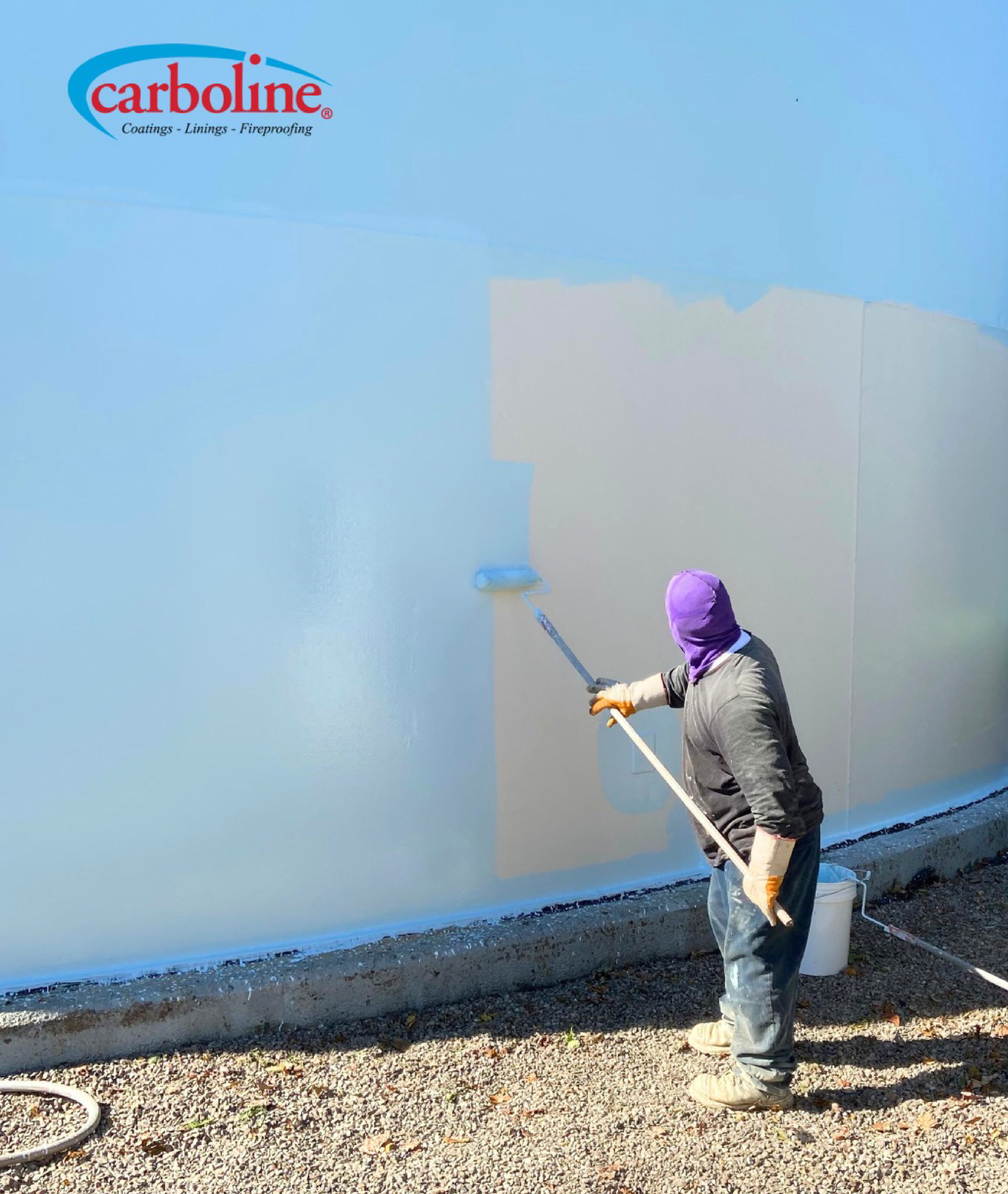 Worker applying protective coating on steel structure